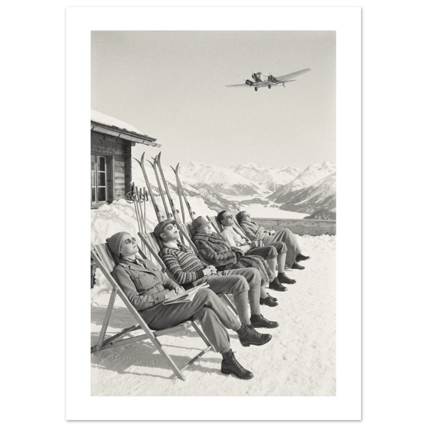 Five guests sunbathing in deckchairs on a snowy mountain terrace with an airliner overhead, 1934 style black and white photo print