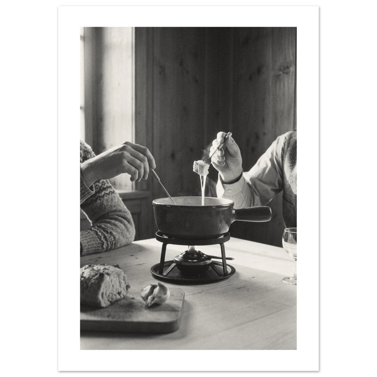 Couple dipping bread into a cheese fondue at a wooden table in a Swiss chalet room, 1932 style black and white photo print